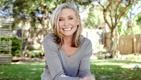 Laughing mature woman relaxing outside in yard in summer