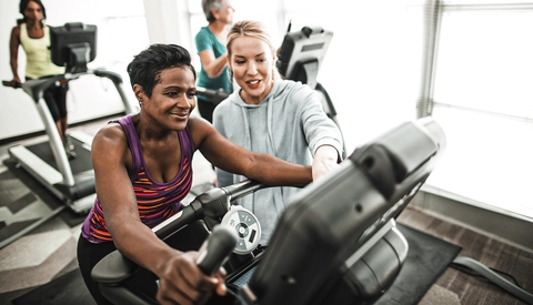 Personal Trainer Showing Woman How To Use Treadmill