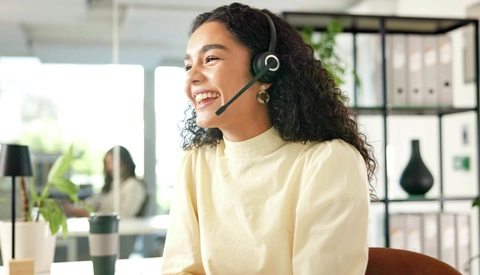Customer service individual with a head set on and smiling
