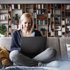 Woman on couch using laptop computer