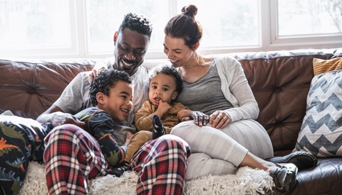 Woman and man holding children and talking 