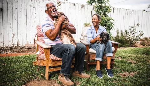 Woman and man holding pets and laughing