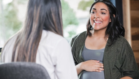 Woman discussing her pregnancy with midwife