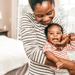 Mom holding newborn baby at home