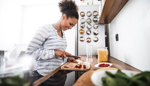 Young woman cutting fruits