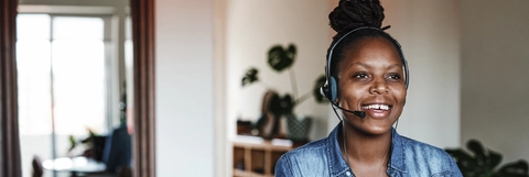 Young woman using a laptop and headset while working from home