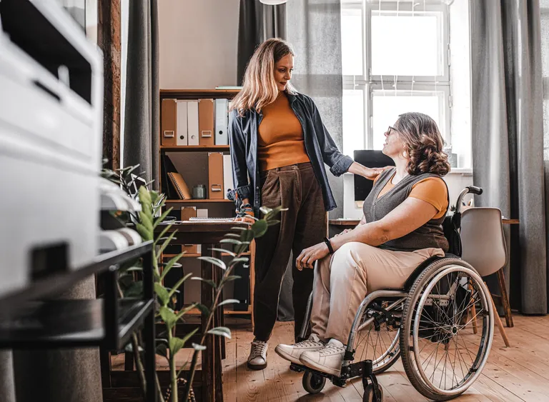 Woman talking to female friend in wheelchair