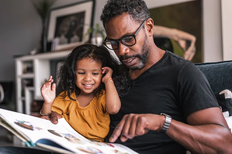 Father reading book to daughter