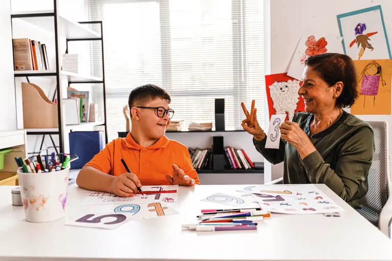 Student who is disabled working on math with teacher
