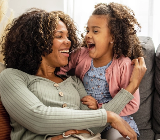 Close up of happy mother hugging her daughter at home