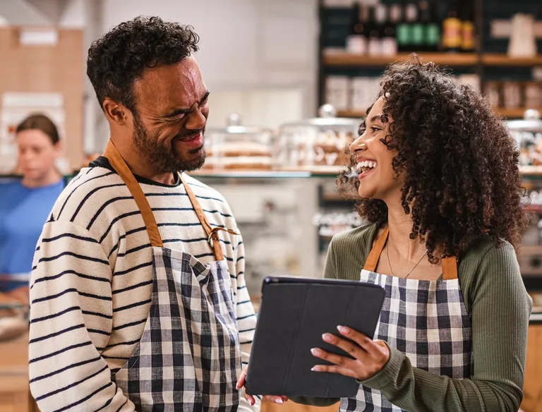 Woman showing digital tablet to man with Down Syndrome