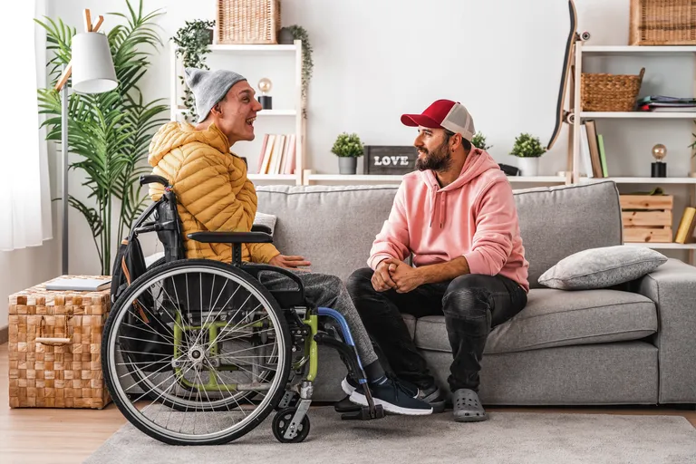 Disabled man in wheelchair and friends chatting