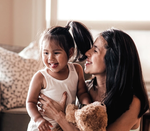 Young mother smiling at her young daughter