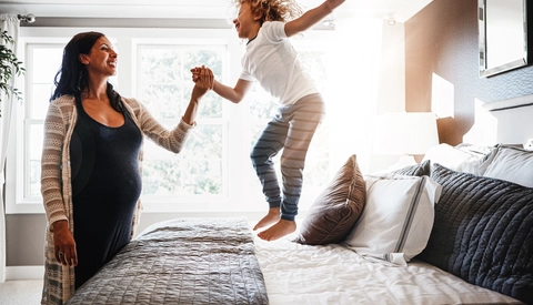 Pregnant woman bonding with her young son at home