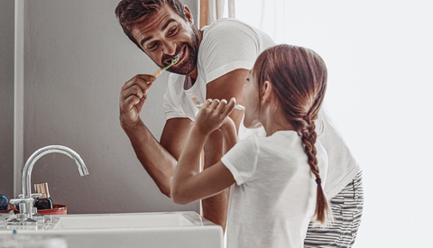 Dad and Young Daughter Brushing Teeth