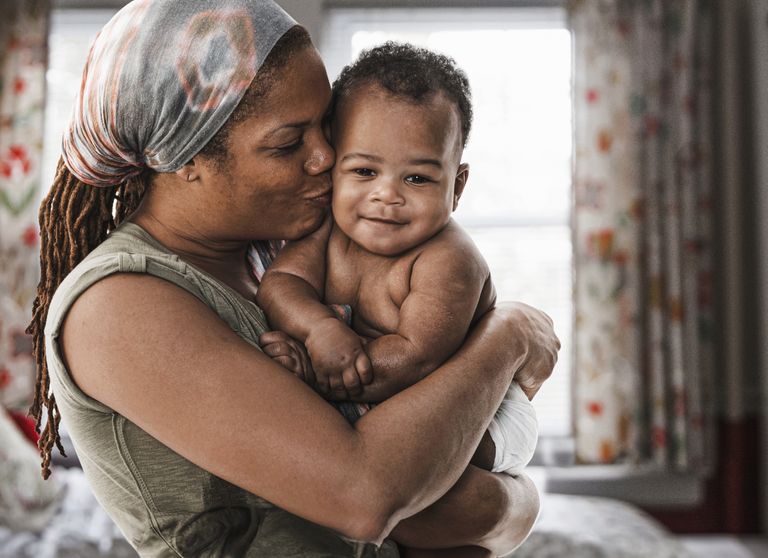 Mother kissing baby son on cheek