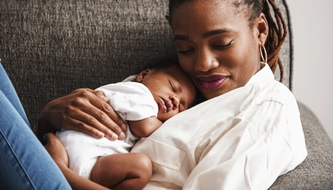 Mother cuddling sleeping baby