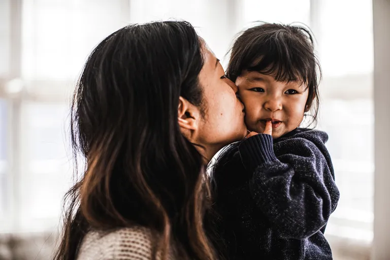 Mother kissing daughter on cheek