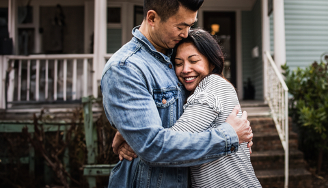 Portrait of young couple in front of home 