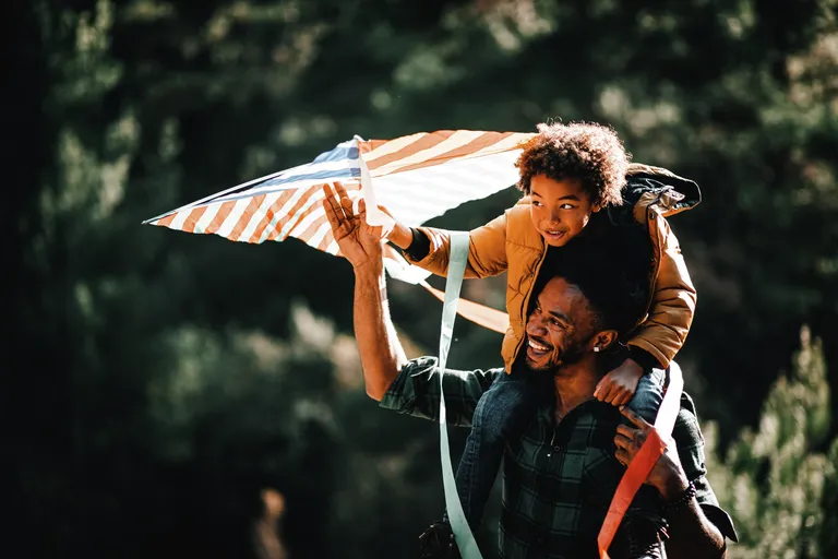 Father and son having fun flying a kite