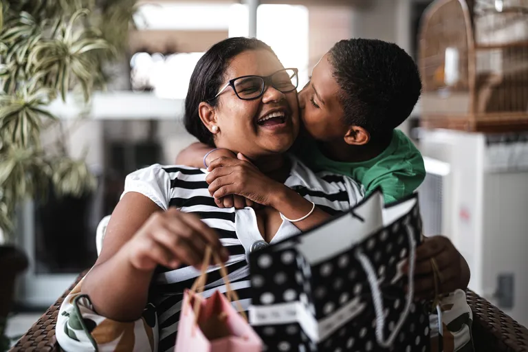 Mother and son embracing and receiving gifts