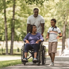 Father and son on walk with grandmother in wheelchair
