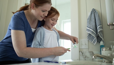 Mother and daughter brushing teeth
