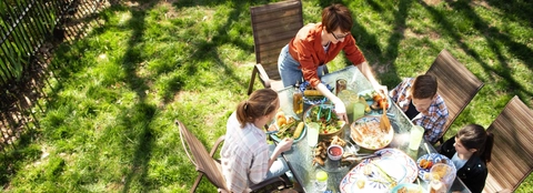 Overhead view of family at table eating meal outdoors