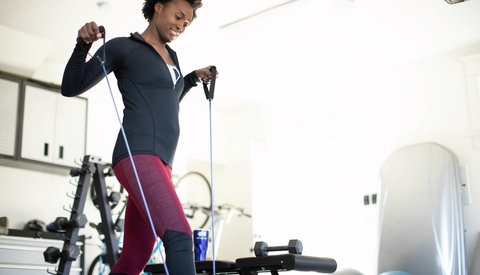 Woman using exercise bands in home gym