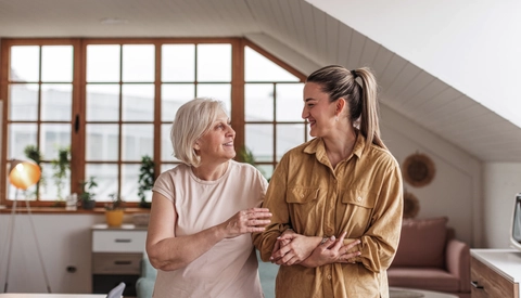 Mature woman walking arm-in-arm with adult female