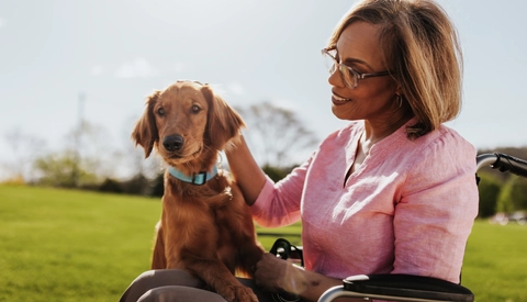 Woman in wheelchair petting a dog
