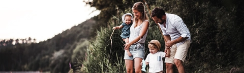 Young family with two toddler children outdoors by the river