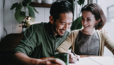 A couple sitting at a table reviewing paperwork.