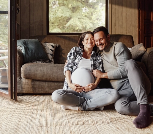 Happy pregnant couple relaxing in the living room