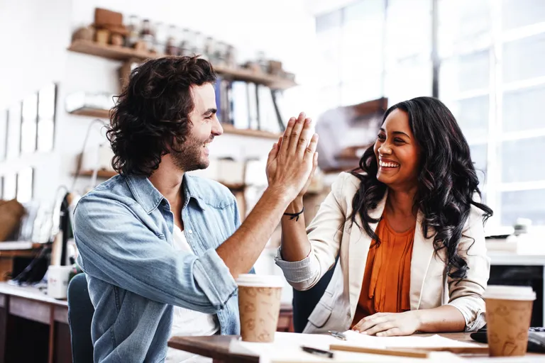 Two young architects high-fiving each other after a job well done