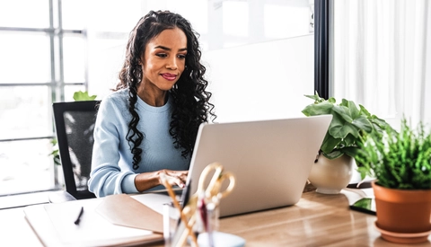 Businesswoman working on laptop in modern office space
