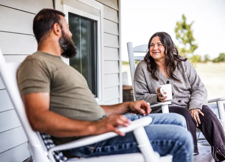 Mid adult couple having coffee at porch