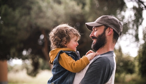 Boy and dad smile at one another