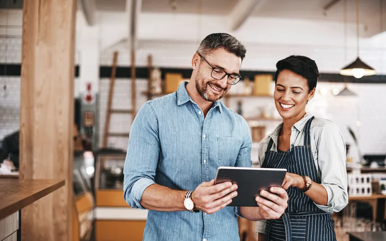 Man and woman using a digital tablet in coffee shop