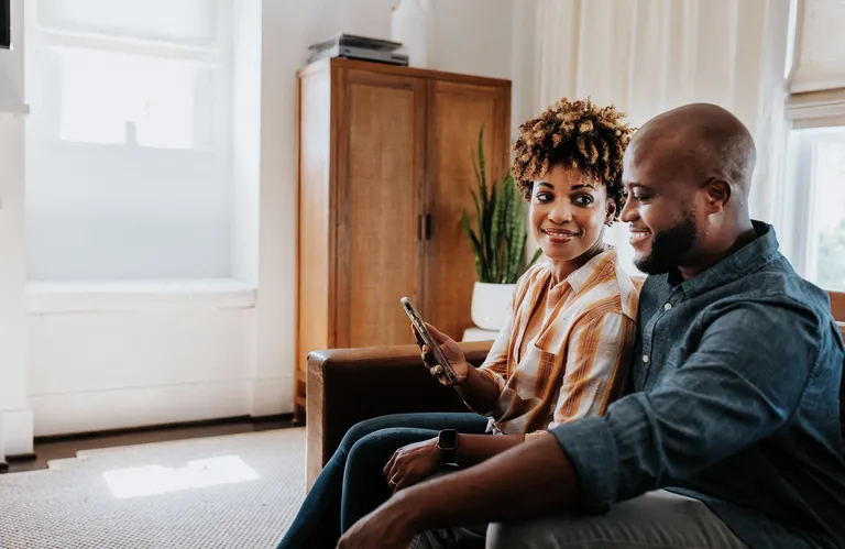 Couple on couch using mobile phone