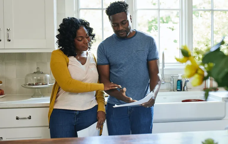 Couple at home checking the mail and reading some letters