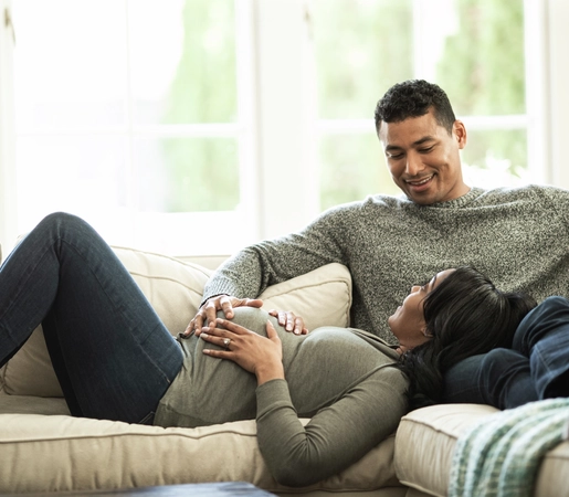 Portrait of pregnant wife relaxing on husband lap