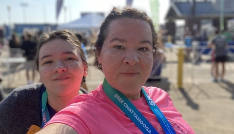 Mother and daughter celebrate their accomplishment after finishing a 5K race together.