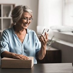 Cheerful retired woman looking at phone