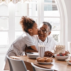 Granddaughter kissing her grandpa during a birthday party