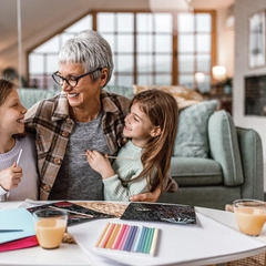 Grandmother and two young granddaughters bonding while doing crafts at home