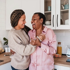 Happy woman enjoying time with mother in kitchen