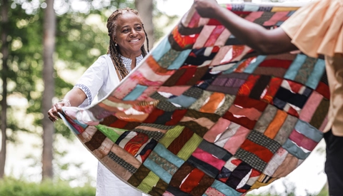 Friends putting down blanket for outdoor picnic
