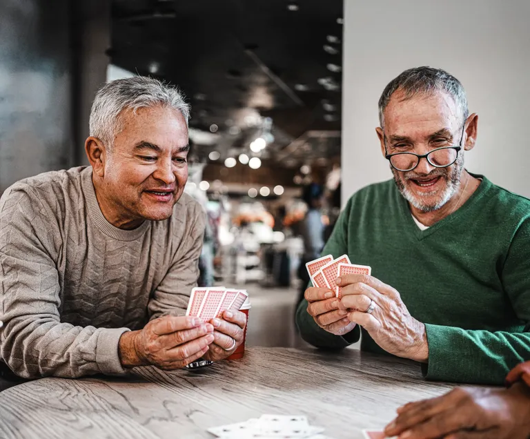 Three senior friends playing a card game