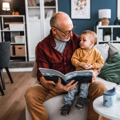 Grandfather reading a book with his young grandson